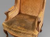 an old chair with a brown upholstered seat and a gold upholstered back