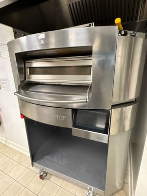 four à pizza en acier inoxydable posé sur un plan de travail dans une cuisine