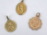 three gold pendants with a picture of a woman and a man