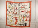an orange and white scarf hanging on a white wall