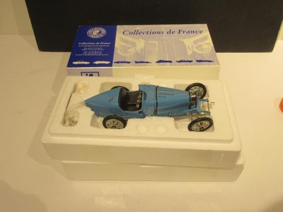 une petite voiture bleue dans une boîte blanche posée sur une table