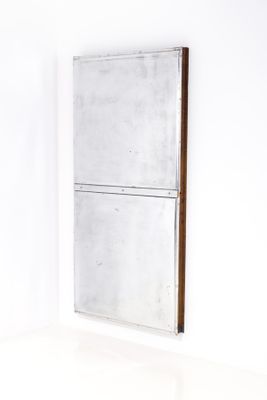mirror in the corner of a room with white walls and a white floor