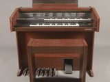 un petit piano en bois avec un banc en dessous