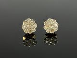 a pair of gold and diamond flower earrings