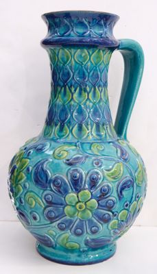 a blue and green vase sitting on a white surface