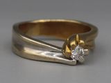 a gold ring with a diamond in it on a table