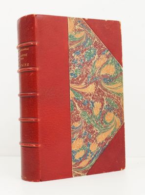 un vieux livre à la couverture rouge ornée d'un motif floral