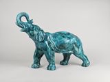 statue of an elephant with a long tusk standing on a white surface