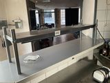 stainless steel counter top in a commercial kitchen with a microwave on it