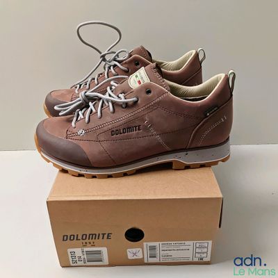 Les chaussures se trouvent dans une boîte posée sur la table, à côté de la boîte.