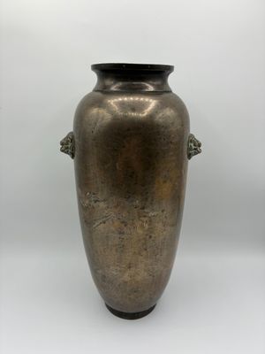 un grand vase en métal muni de deux anses, sur fond blanc