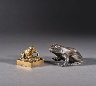 deux figurines de grenouilles en argent et en or, posées l'une sur l'autre