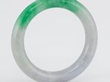 un gros plan d'un anneau vert et blanc sur une surface blanche