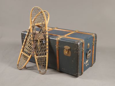 une paire de raquettes posée à côté d'une valise