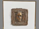 un gros plan sur une sculpture représentant le visage d'un homme dans un cadre