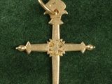 gold plated cross on green velvet with a cross on it