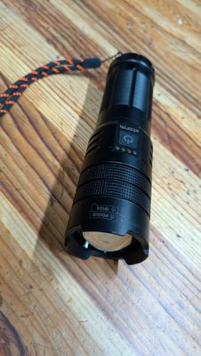 une lampe de poche posée sur une table en bois