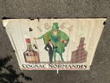 une enseigne sur le côté d'un immeuble sur laquelle on peut lire « Cognac Norman »