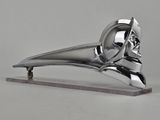 une sculpture en argent représentant un oiseau, posée sur un socle