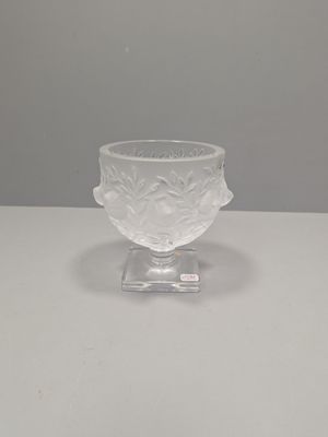 un saladier en verre transparent posé sur une table blanche, avec un fond gris en arrière-plan