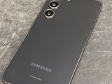 a close up of the back of a black samsung phone on a table