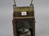 a small metal lantern with a wooden handle on a table