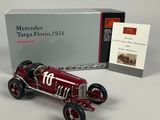 an old model of a red race car next to a boxed box