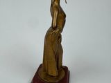statue of a woman with a hat on her head on a wooden base