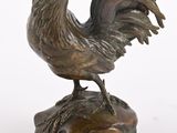 bronze statue of a rooster on a rock on a white background