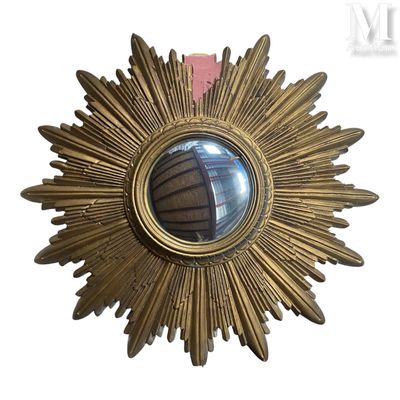 un miroir doré en forme d'étoile accroché au mur