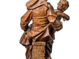 an image of a wooden statue of a man holding a child
