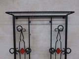 a black iron rack with two red hearts hanging from it