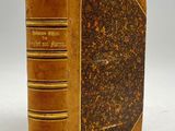 an old book with a brown cover sitting on top of a table