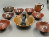 de nombreux bols et tasses sur la table, ainsi qu'un pichet