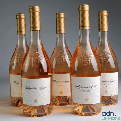 Quatre bouteilles de vin rosé sont alignées sur une table