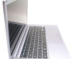 a silver laptop with a black keyboard on a white surface