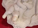 a statue of a baby sitting on a pillow