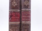 two old books sitting on top of each other on a white surface