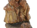 une statue représentant deux enfants et un chien sur un rocher