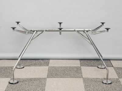 une image représentant une table en métal à quatre pieds posée sur un sol en damier