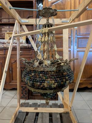 un grand objet métallique posé sur un socle en bois dans une pièce