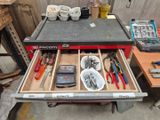 many tools in the drawer of a workbench in the garage