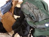 a pile of clothes that is on a bed