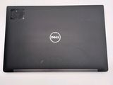 the dell laptop is sitting on a white surface with its lid open
