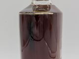 a close up of a bottle of liquor on a white surface