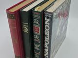 several books are stacked on top of each other on a white surface