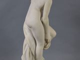 a white statue of a woman with a flower in her hair