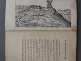 an old book with a drawing of a lighthouse on top of a hill