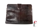 un gros plan d'un sac à main en peau de serpent marron sur fond blanc