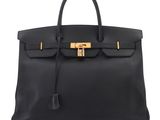 a black leather handbag with a gold lock on the handle